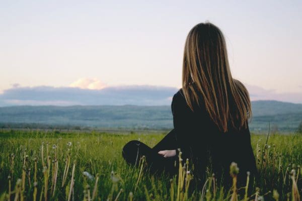 serene nature landscape with a person sitting or lying down, appearing to be relaxed and at peace